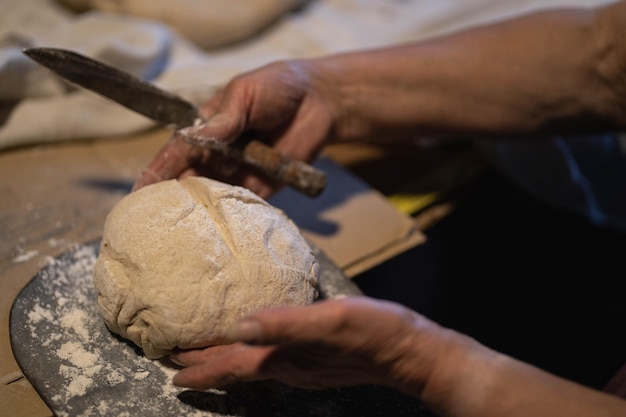 Donna che prepara e taglia il pane