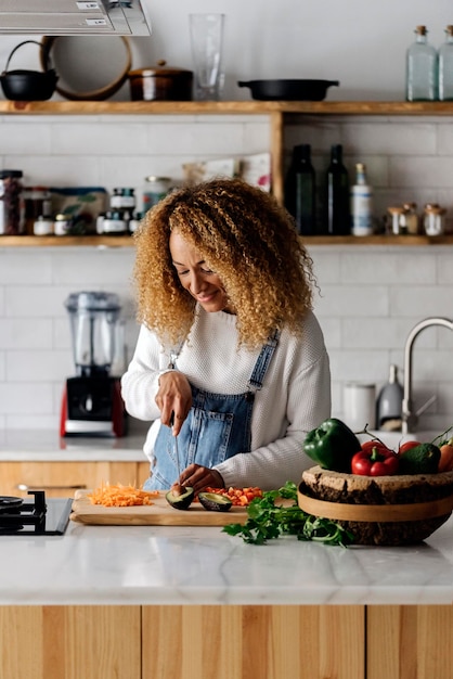 Donna che prepara il cibo in cucina a casa.