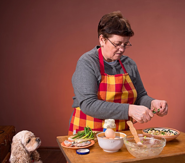 Donna che prepara insalata su sfondo arancione