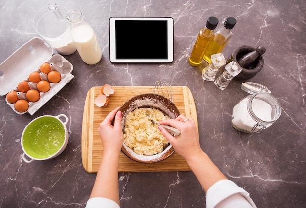 Donna che prepara la pasta dalla ricetta sul suo tablet