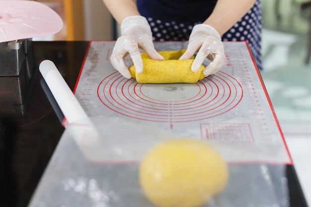 Donna che prepara la pasta di pane sul tavolo della cucina