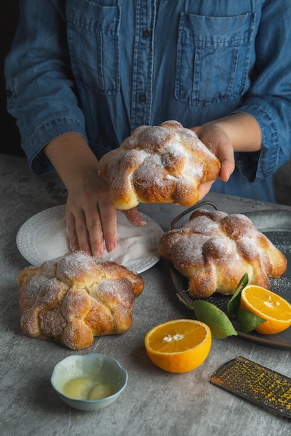 Donna che prepara Pan de muertos pane dei morti per il giorno dei morti messicano