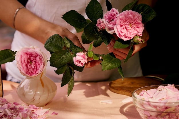 Donna che prepara petali di rose di tè Marmellata di rose di tè naturale fatta in casa estetica che prepara con zucchero, limone e petali di rose di tè Ricetta sana Fotografia di stile di vita