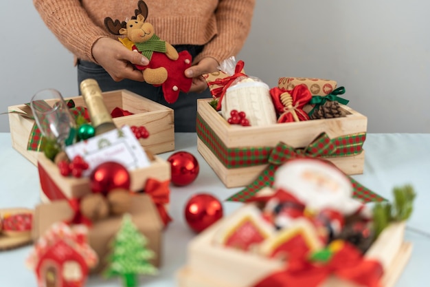 Donna che prepara scatole di regali di Natale