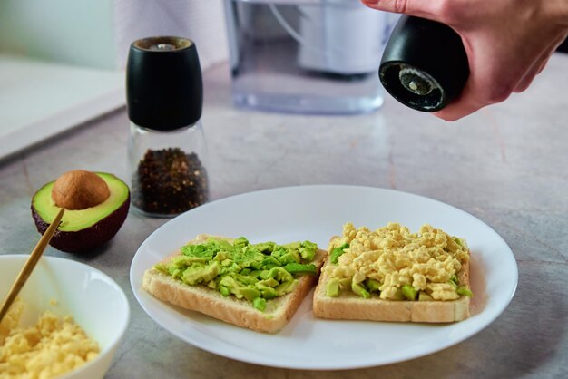 Donna che prepara toast con avocado Cibo sano e concetto di dieta Prodotto biologico