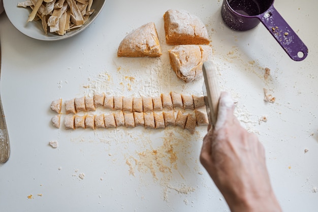 Donna che produce gli gnocchi fatti in casa della patata dolce