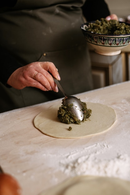 Donna che produce gli gnocchi in cucina