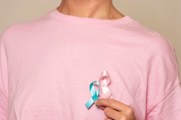 Donna che promuove la consapevolezza del cancro al seno con nastro rosa e blu per uomini e donne