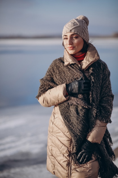 Donna che propone in inverno in riva al lago