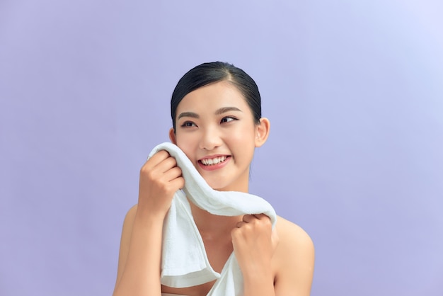 Donna che pulisce la pelle del viso con un asciugamano dopo aver lavato il viso ritratto