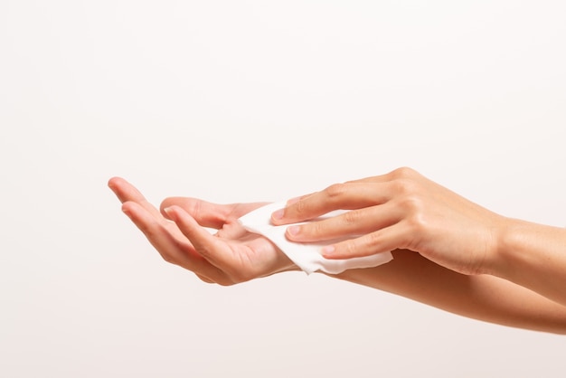 Donna che pulisce le sue mani con carta velina bianca
