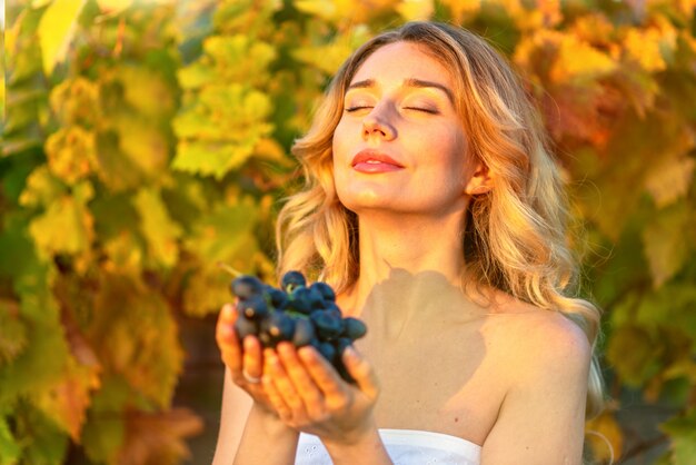 Donna che raccoglie l'uva dalla vigna