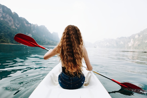 Donna che rema una canoa attraverso un parco nazionale