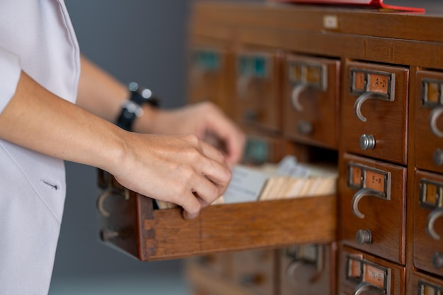 Donna che ricerca negli archivi nella biblioteca del catalogo delle carte all'università