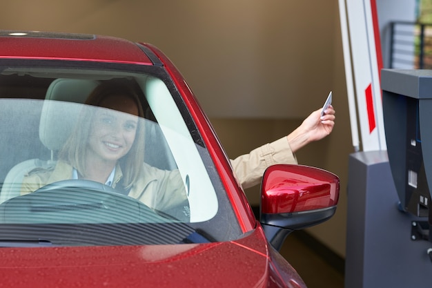 donna che riceve il biglietto dal parchimetro nel parcheggio sotterraneo?