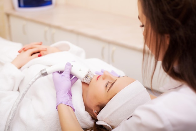 Donna che riceve un massaggio hardware GPL presso la clinica di bellezza Estetista professionista che lavora