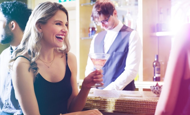 Donna che ride o beve un cocktail durante la festa di compleanno di una festa notturna o un evento di Capodanno nel bar discoteca discoteca o ristorante di lusso Sorridi felice o lega amici e bicchiere di alcol o scherzo comico