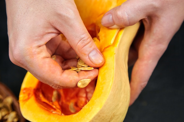 Donna che rimuove i semi di zucca e le fibre fibrose