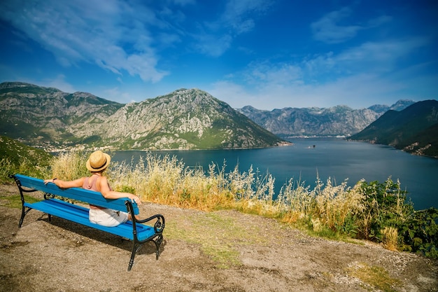 Donna che riposa su una panchina nel luogo romantico nelle montagne della baia di Kotor