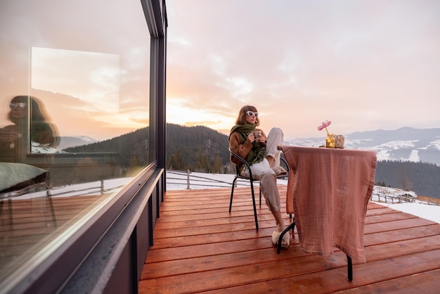 Donna che riposa sulla terrazza della casa in montagna