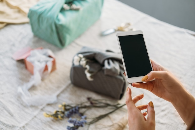 Donna che scatta foto di un regalo incartato a mano zero rifiuti furoshiki confezione regalo giapponese ringraziamento zero