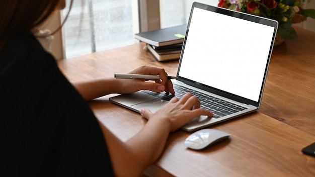 Donna che scrive sul computer portatile con lo schermo in bianco