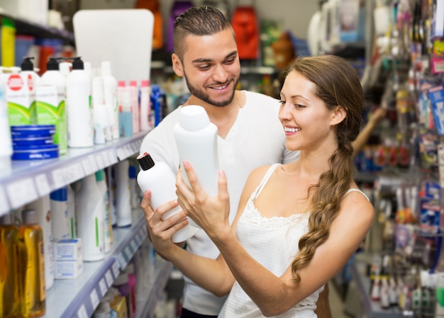 Donna che seleziona lo shampoo in negozio