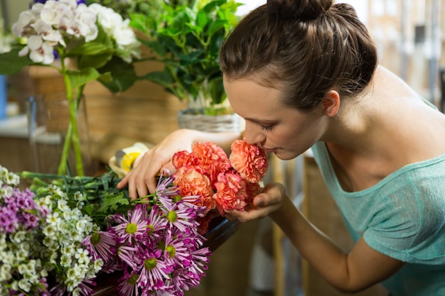 Donna che sente l'odore di un mazzo di fiori