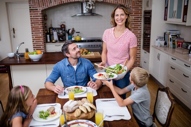 Donna che serve cibo alla sua famiglia in cucina