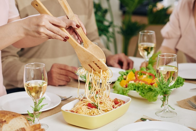 Donna che serve gli spaghetti a cena