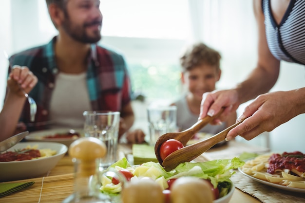 Donna che serve un pasto alla sua famiglia