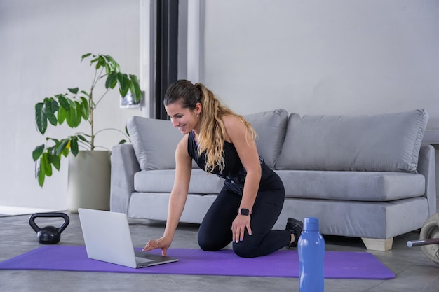 Donna che si allena online con attrezzature per il fitness