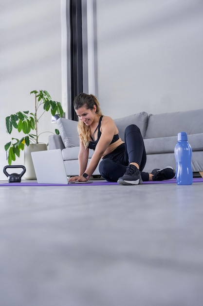 Donna che si allena online con attrezzature per il fitness