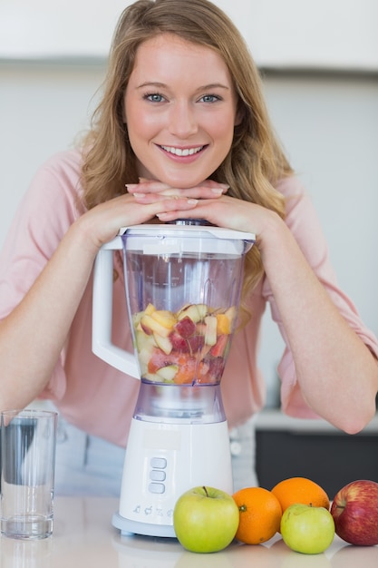 Donna che si appoggia sul liquidatore mentre si prepara il succo di frutta