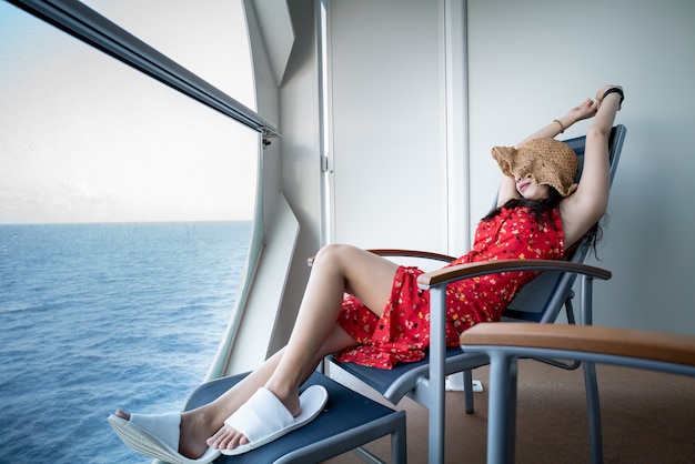 Donna che si distende sulla nave da crociera godendo la vista sull&#39;oceano dal balcone