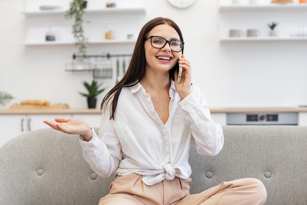 Donna che si diverte a comunicare con i colleghi mentre è seduta su un comodo divano