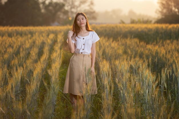 Donna che si diverte al campo di orzo in estate