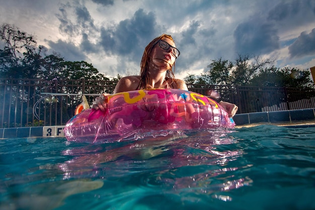 Donna che si diverte in piscina contro il cielo