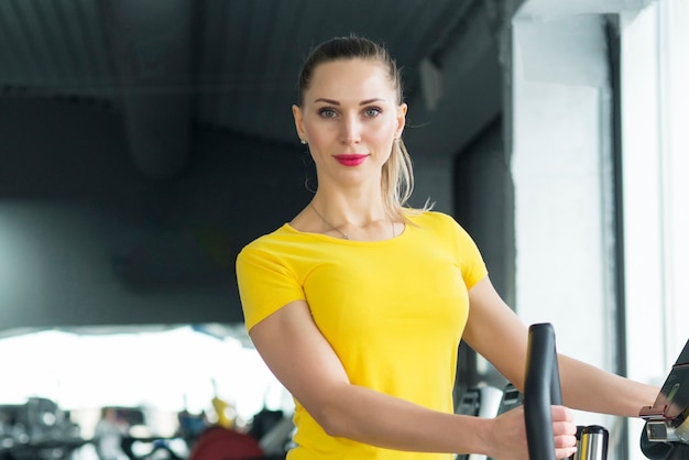 Donna che si esercita in palestra in un trainer ellittico Cardio training