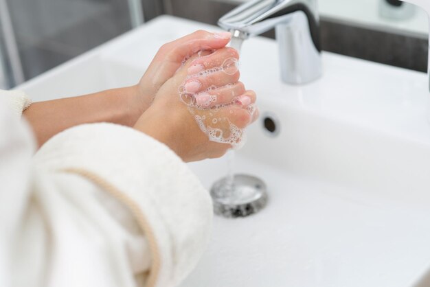 Donna che si lava le mani con il primo piano del sapone