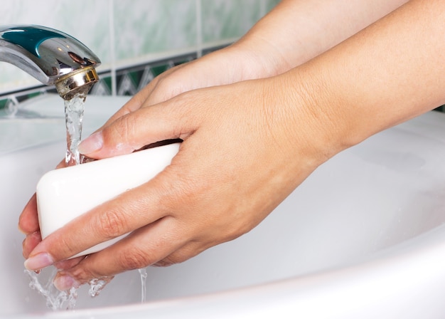 Donna che si lava le mani con il primo piano del sapone