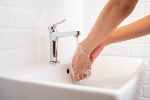 Donna che si lava le mani nel bagno di casa