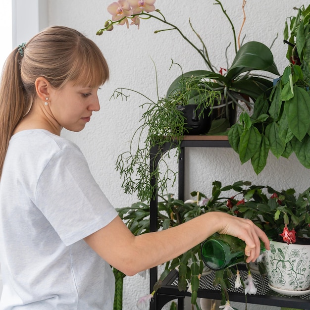 Donna che si occupa delle piante in vaso sul giardinaggio del balcone a casa hobby del pollice verde