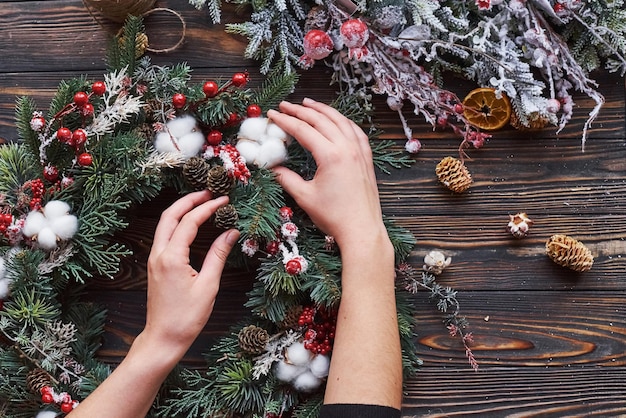 Donna che si prende cura dell'ornamento. Vista dall'alto della cornice festiva di natale con decorazioni di capodanno.