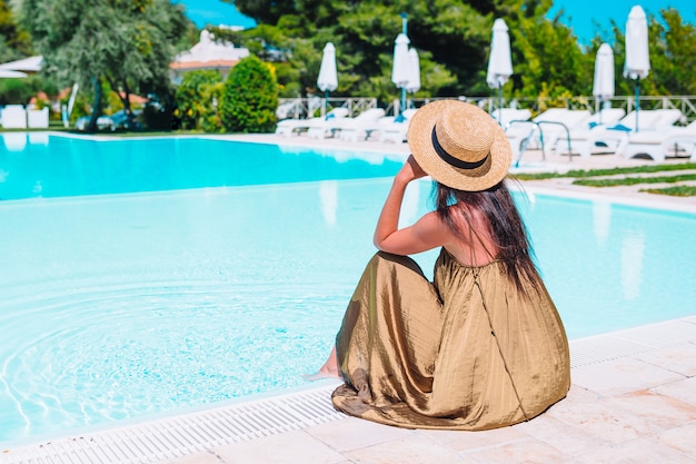 Donna che si rilassa a bordo piscina in un resort di hotel di lusso godendo la vacanza perfetta vacanza al mare