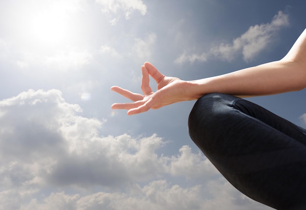 Donna che si rilassa in posizione di yoga in una giornata di sole