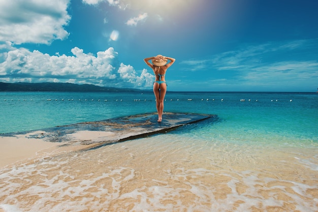 Donna che si rilassa sotto il sole al mare cristallino