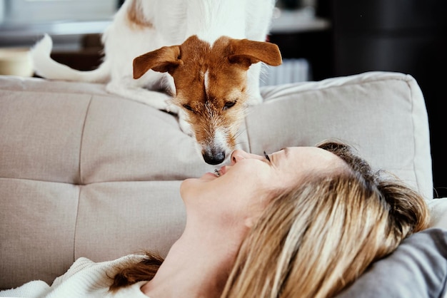 Donna che si rilassa sul divano con il suo cane