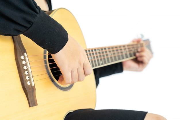 Donna che si siede e che gioca la canzone folk della chitarra della chitarra in sua mano