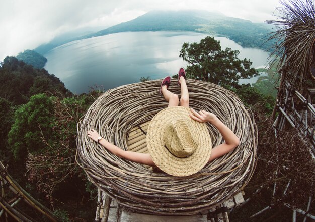 Donna che si siede su una collina che osserva il paesaggio stupefacente. Ragazza che viaggia in Asia